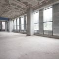 A large, empty interior of a building. The interior is raw and unfinished, with no furnishings or lighting fixtures.
