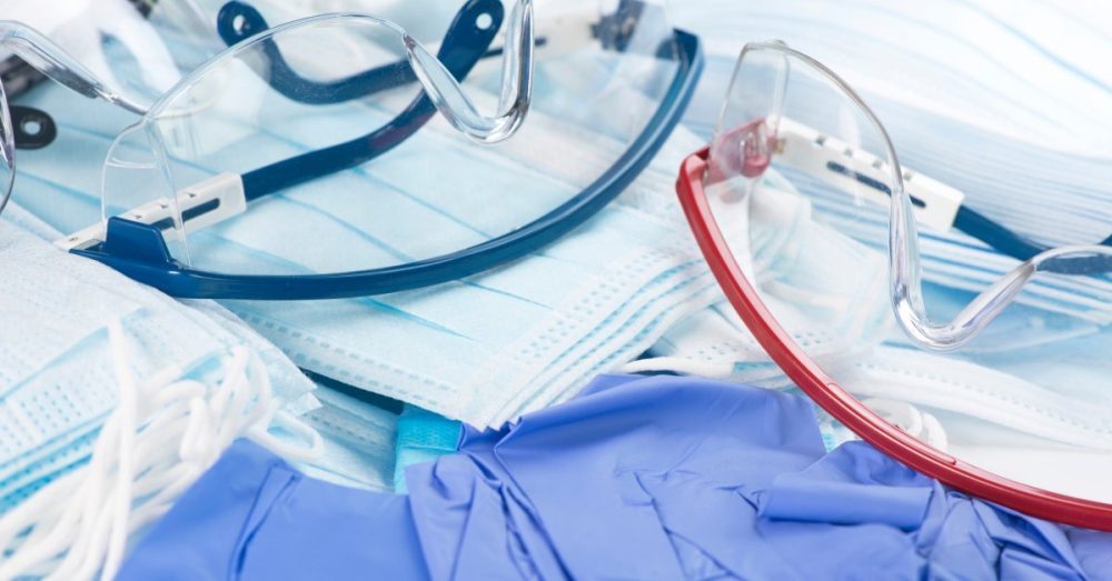 A collection of personal protective equipment including masks latex gloves and transparent safety glasses